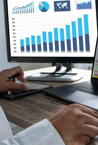 Person writing on a graph paper with colorful data bars and charts.